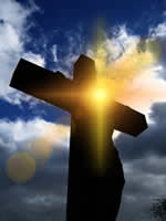 Click to enlarge this beautiful public domain copyright free photograph of the sun and lens flares in front of the silhouette of Jesus Christ our savior on the cross.